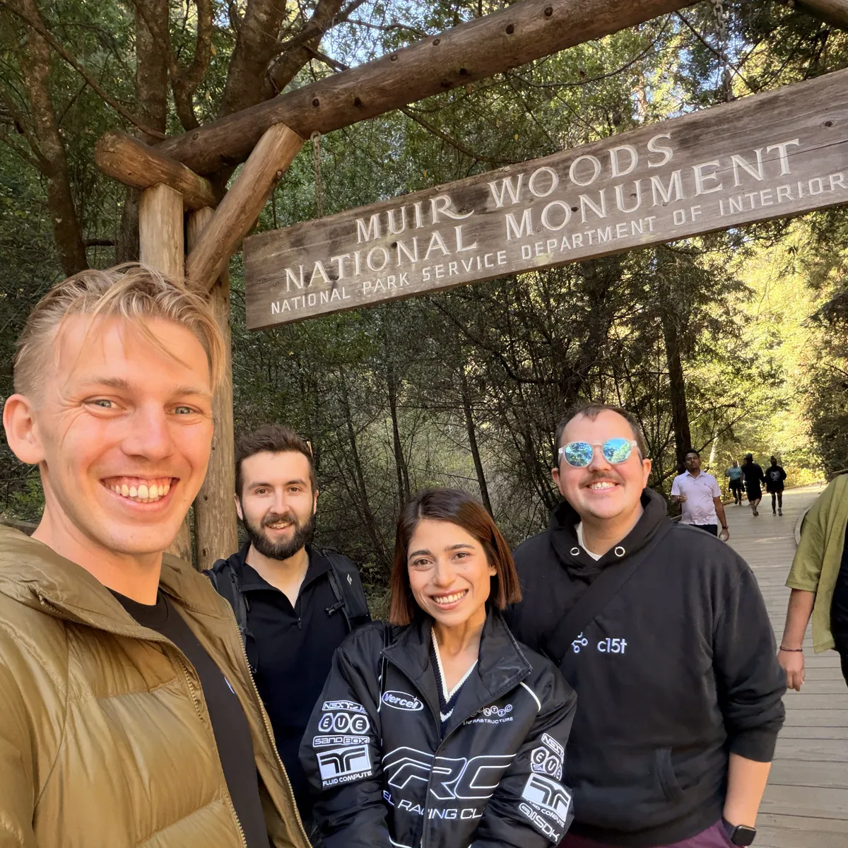 Selfie of Jono, Sne in a Vercel Racing Club jacket, and Chris and Will from Inth under the Muir Woods National Monument sign